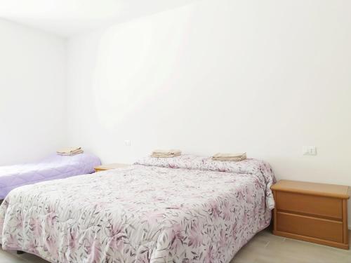 a bedroom with a bed and a dresser and a bed sidx sidx at Levico Al Corso Apartments in Levico Terme