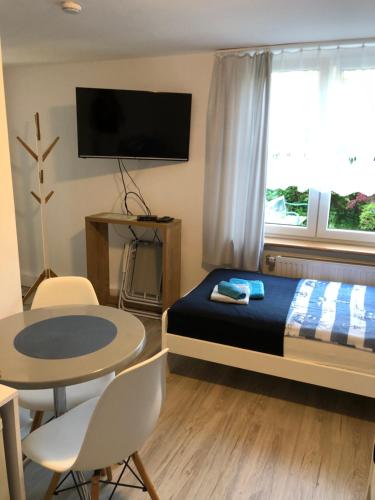 a bedroom with a bed and a table and a tv at MORSKIE FALE in Kołobrzeg