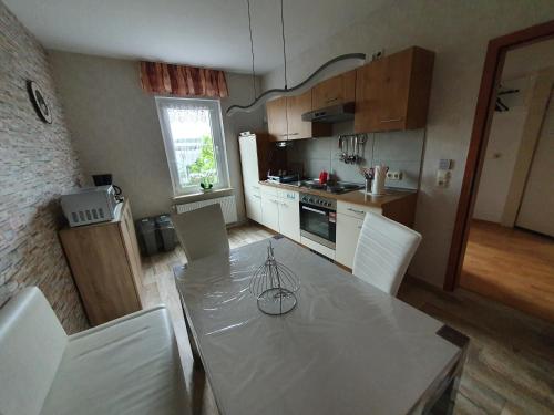 a kitchen with a table with white chairs and a counter top at Ferienwohnung-Thale-Ritter II in Thale