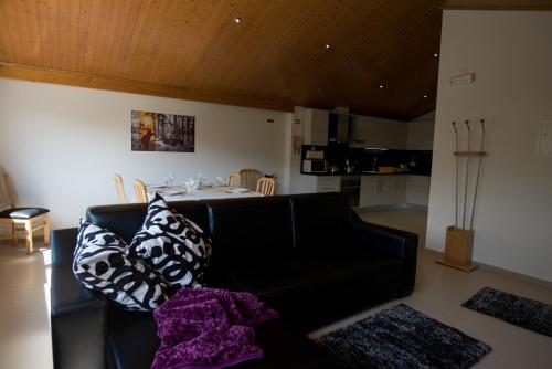 a living room with a black couch and a table at Casas do Mondego in Porto da Carne