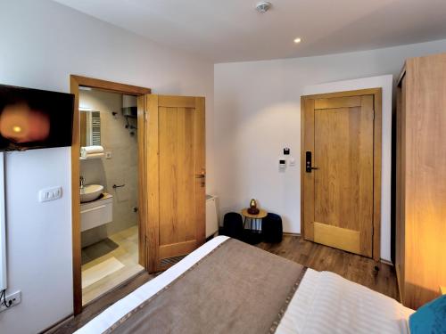 a bedroom with a bed and two wooden doors at Villa Gunga in Mostar