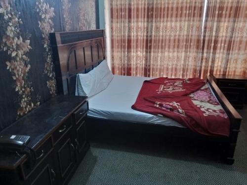 a small bedroom with a bed and a dresser at HOTEL DE GRAND in Rawalpindi