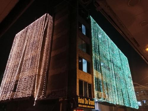 two tall buildings are decorated with christmas lights at HOTEL DE GRAND in Rawalpindi