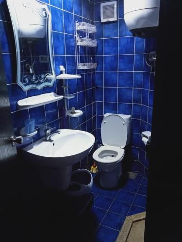a blue tiled bathroom with a toilet and a sink at Chalets in Porto Matrouh Families Only in Marsa Matruh