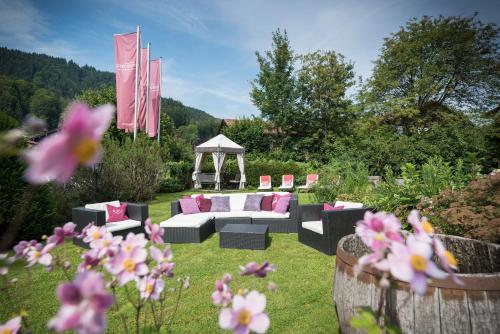 a garden with a couch and a gazebo at Landhaus Ertle in Bad Wiessee