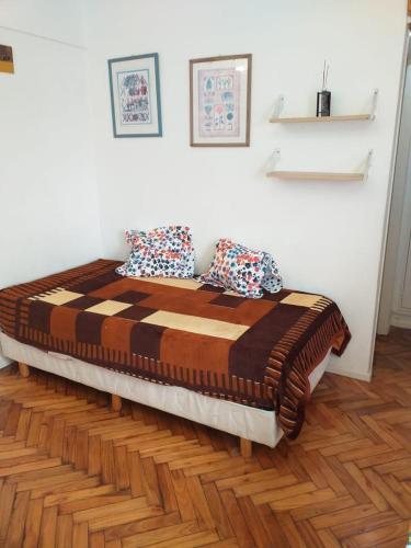 a large bed in a room with a wooden floor at Carlos Calvo in Buenos Aires