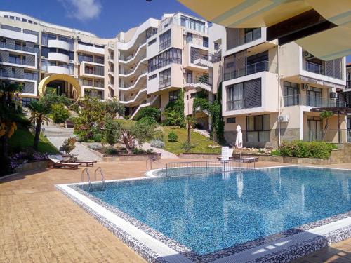 a swimming pool in front of some apartment buildings at Dolce Vita II Waterfront Breeze Sea View Luxury Apartament in Sveti Vlas
