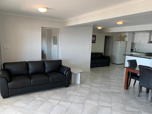 a living room with a black couch and a table at Beachside & Jetty View Apartment 6 - Captain's Apt in Streaky Bay
