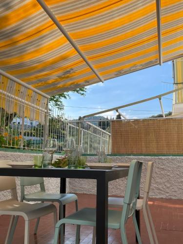 einen Tisch und Stühle unter Markise auf einer Terrasse in der Unterkunft Gigi's house in Alassio