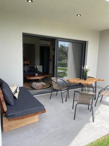 a living room with a couch and a table and chairs at MOLA PAPAYA STUDIOS in Mola Kalyva