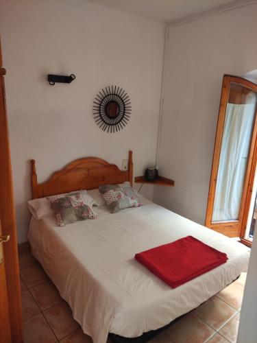 Un dormitorio con una cama con una manta roja. en APARTAMENT CAN MINGU 1er pis, en Besalú