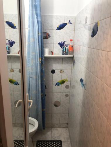 La salle de bains est pourvue d'une douche avec des étiquettes de poisson sur le mur. dans l'établissement Apartament situat aproape de mare, à Constanţa