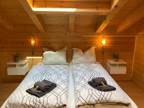 Un dormitorio con una cama con dos sombreros. en Haus Sapporo en Grindelwald