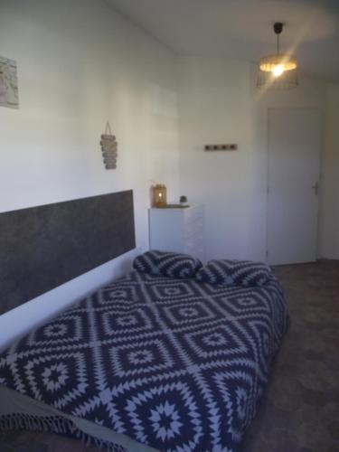 Un dormitorio con una cama con una manta azul y blanca. en Pétale de RoZ au pied du Mont Saint Michel, en Roz-sur-Couesnon