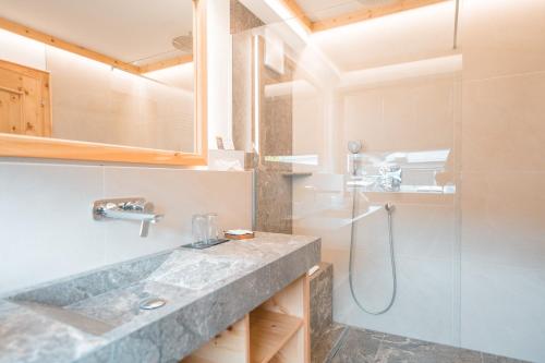 a bathroom with a sink and a shower at Hotel Schartner in Altenmarkt im Pongau