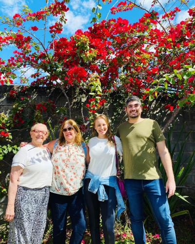 a group of people standing in front of a tree with red flowers at POUSADA CHARLOTTE in Tiradentes