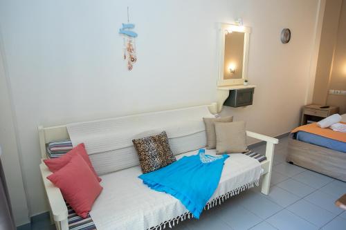 a white bench with colorful pillows on it in a room at Rania Studios in Gouves