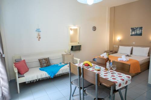 a hotel room with two beds and a table and a dining room at Rania Studios in Gouves