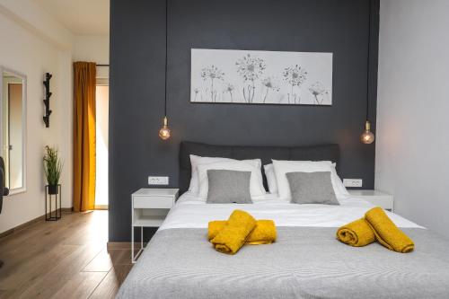 a bedroom with a large white bed with yellow pillows at Apartments Residence Radovan 1 in Poreč