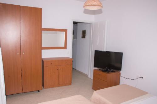 a living room with a television and a wooden cabinet at Villa Erofili Plakias south Rethimno Crete in Asómatoi
