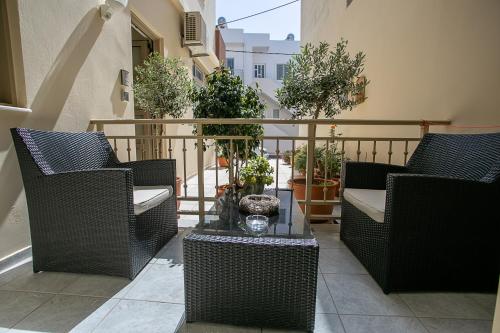 a balcony with wicker chairs and a glass table at Rania Studios in Gouves