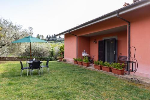 een terras met een tafel, stoelen en een parasol bij La Tana delle Stelle B&B di Charme e Relax in Fara in Sabina