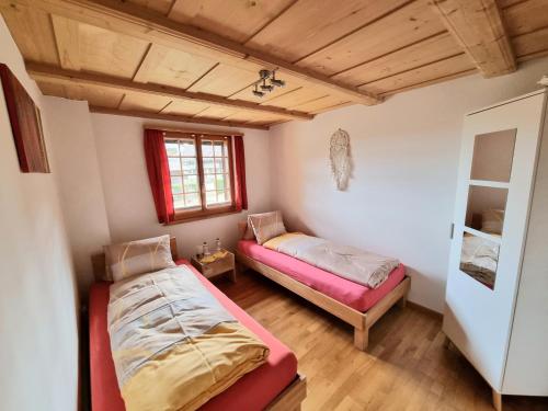 1 Schlafzimmer mit 2 Betten und einem Fenster in der Unterkunft Lodge 24 in Illiswil