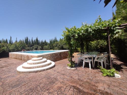 eine Terrasse mit Tisch und Stühlen und einem Pool in der Unterkunft El Galindón Rancho in La Puebla de los Infantes