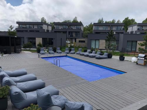 a swimming pool with couches and chairs in front of some buildings at SUN HOME in Palanga