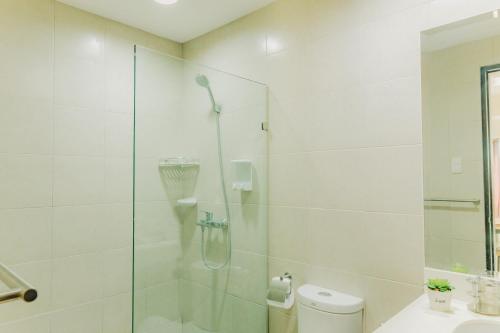 a bathroom with a shower with a glass door at Ayala Mall 10mins walk Cebu City Apartment & Pool in Cebu City