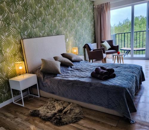 a bedroom with a large bed and a balcony at Bałtyk 44 na Wydmach in Międzywodzie