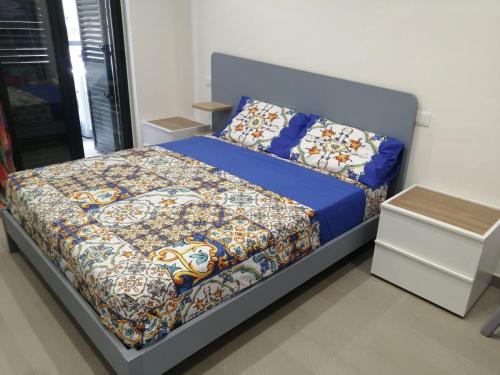 1 dormitorio con 1 cama con edredón azul en casa Marinello, en Oliveri