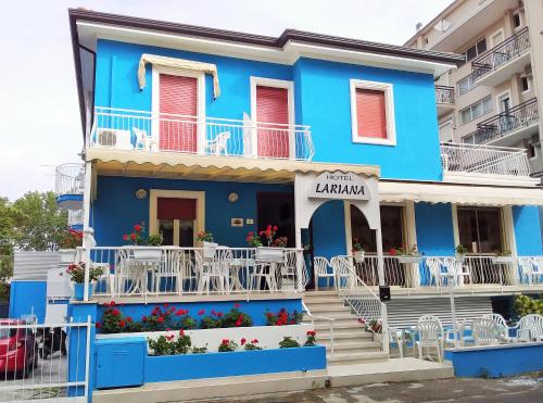 ein blaues Gebäude mit weißen Balkonen und Treppen in der Unterkunft Hotel Lariana in Rimini