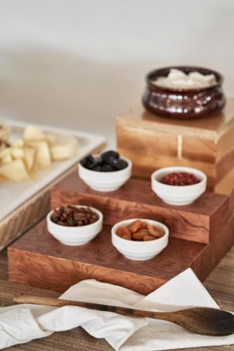 a group of bowls of food on a wooden cutting board at Xenia Poros Image Hotel in Poros