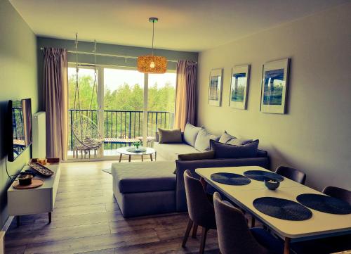 a living room with a couch and a table at Bałtyk 44 na Wydmach in Międzywodzie