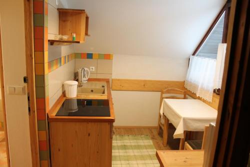 a small kitchen with a sink and a table at Apartments and rooms Cerkovnik in Bohinj