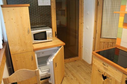 a small kitchen with a microwave on a counter at Apartments and rooms Cerkovnik in Bohinj