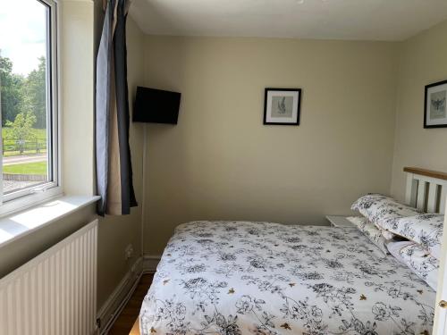 Yew Tree Bungalow, Onneley, Cheshire في كرو: غرفة نوم صغيرة بها سرير ونافذة