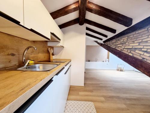a kitchen with a sink and a brick wall at Apartments Lara 2 in Piran