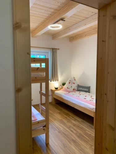 a small bedroom with a bunk bed and a ladder at Bergheimat in Bad Goisern