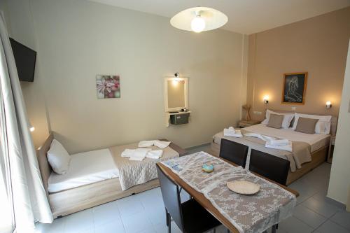 a hotel room with two beds and a table at Rania Studios in Gouves