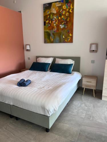 a bedroom with a bed with a painting on the wall at Whaaw Herentals in Herentals