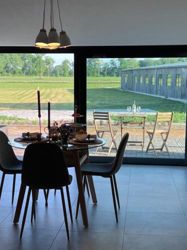 a dining room with a table and chairs and a large window at Whaaw Herentals in Herentals