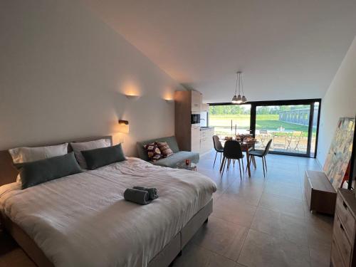 a bedroom with a large bed and a living room at Whaaw Herentals in Herentals
