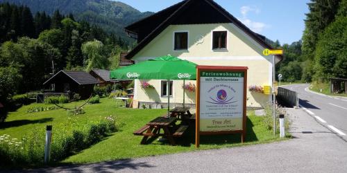 a sign in front of a house with a building at Gössl, Apartement und Doppelzimmer in Mariazell