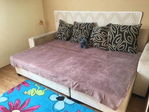 ペーチにあるÁrnyas apartmanの紫の毛布とテディベアが付いたベッド