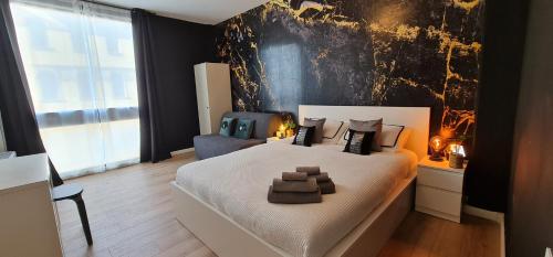 una camera da letto con un grande letto bianco con cuscini marroni di TokiTakai Collection a Padova