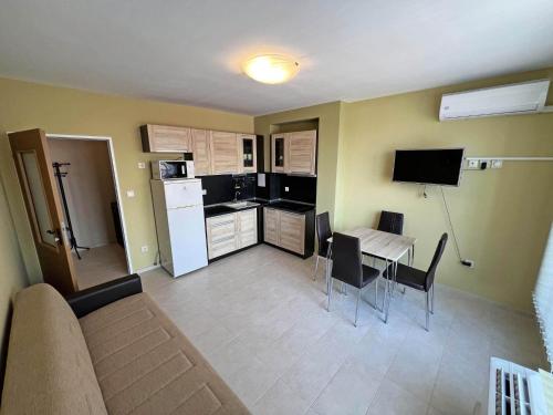 a living room with a kitchen and a table with chairs at Valemar Apartments in Pomorie