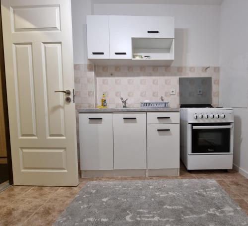 uma cozinha com electrodomésticos brancos e uma porta branca em Birchwood place em Saraievo