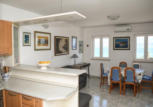 eine Küche und ein Wohnzimmer mit einem Tisch und Stühlen in der Unterkunft Apartment Frida in Supetar